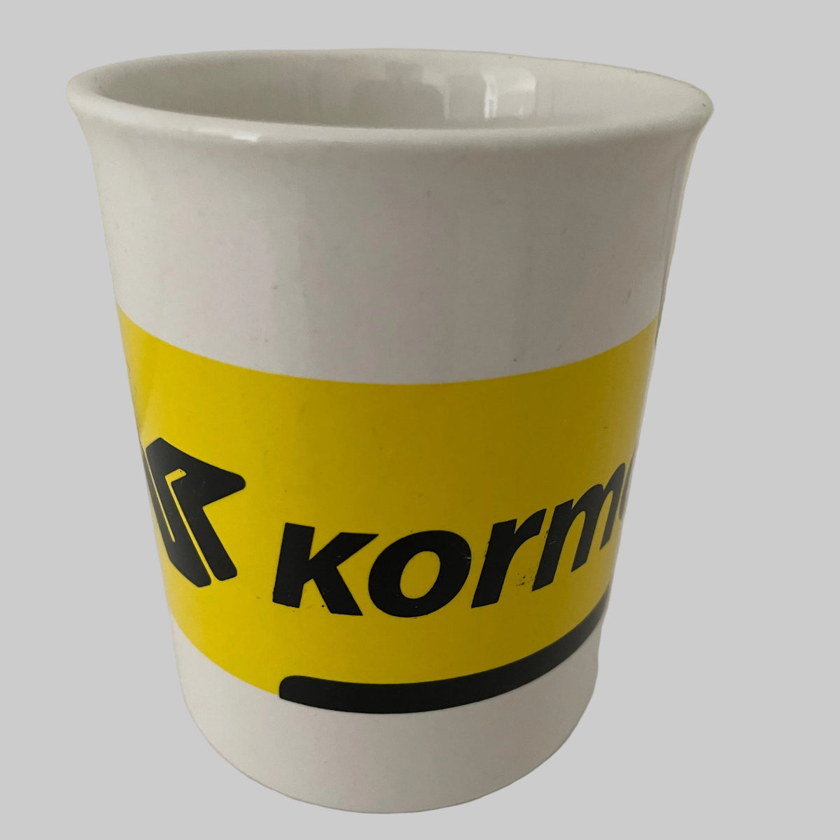 Mug Kormoran blanc avec bande jaune et logo noir – objet publicitaire automobile