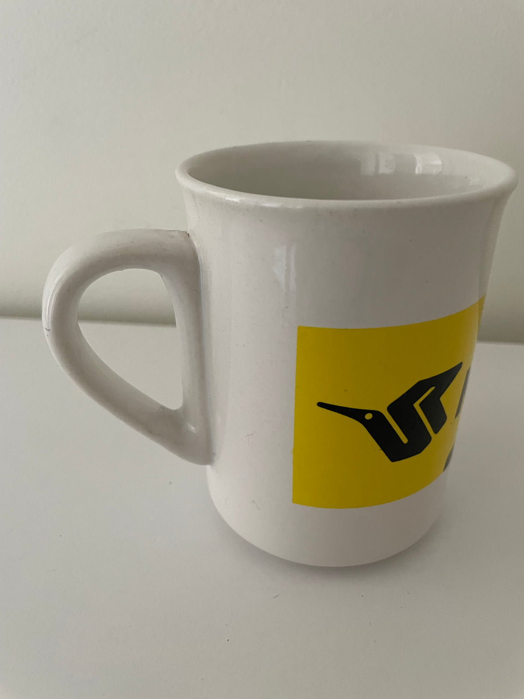 Vue arrière du mug Kormoran avec logo noir sur bande jaune