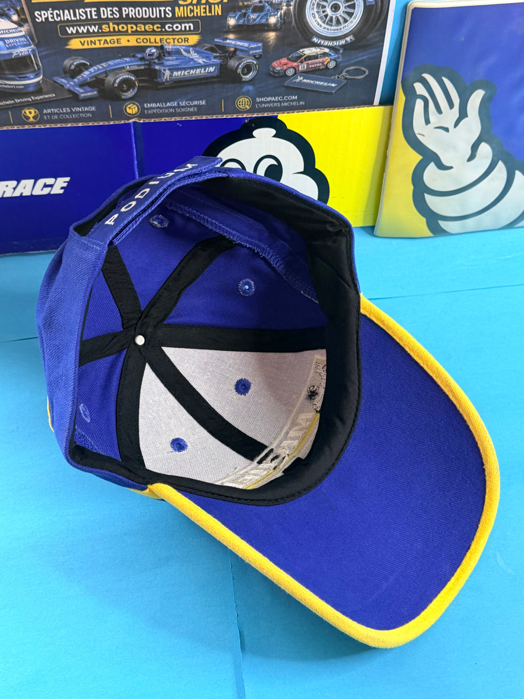 Vue intérieure casquette Michelin Podium neuve avec visière bleue bordée de jaune et système de réglage arrière