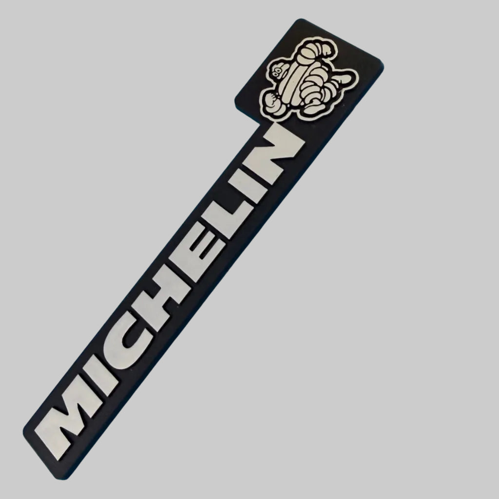 Plaque badge Michelin Bibendum 14 × 3 cm neuve avec lettrage MICHELIN blanc sur fond noir