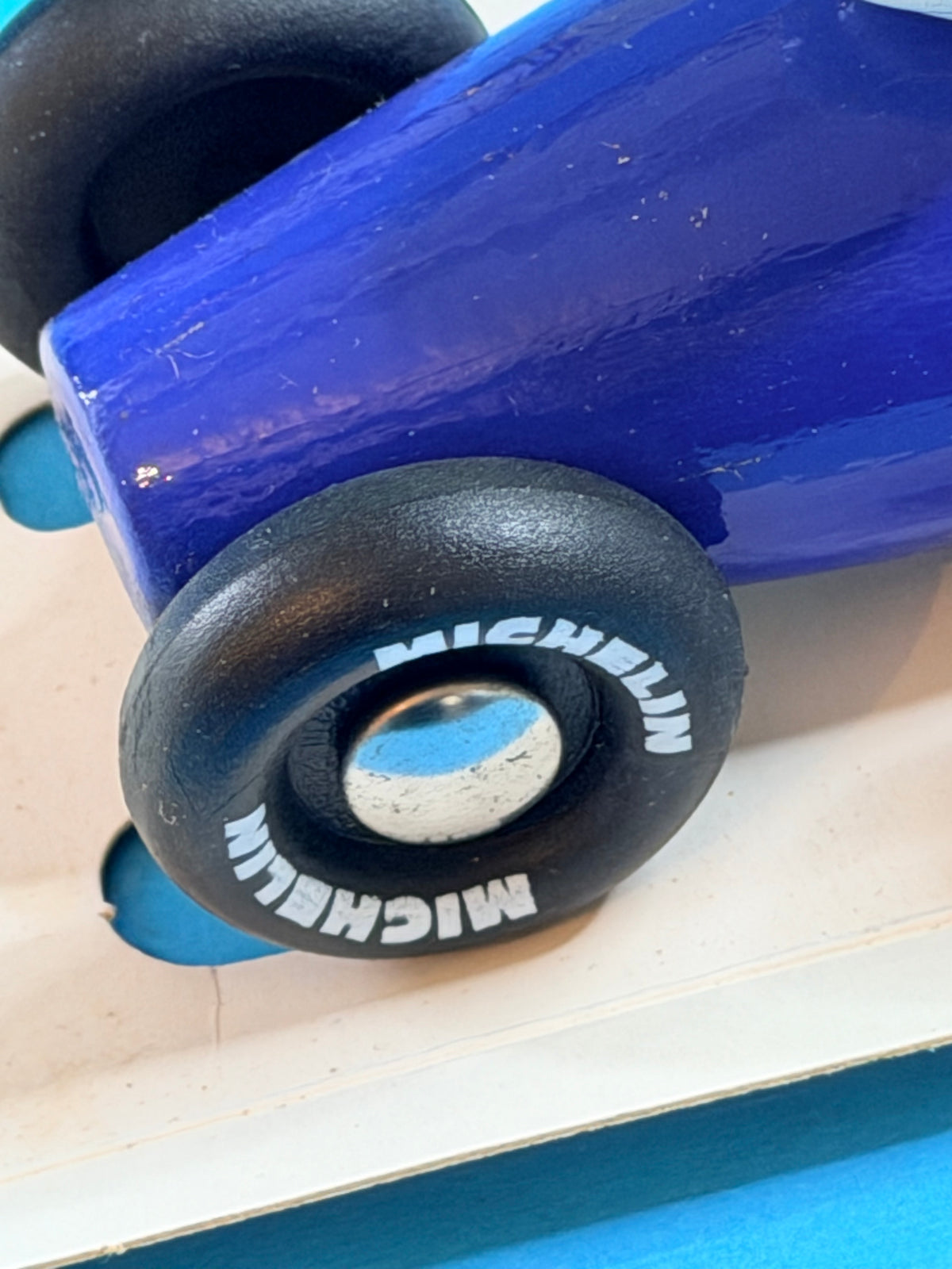 Détail du pneu marqué Michelin sur jouet VILAC Formula 1 bleue
