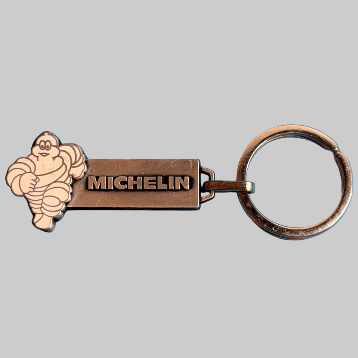 Porte-clés Michelin Bibendum vintage en métal Fraisse Paris, vue de face avec logo MICHELIN et Bibendum blanc.