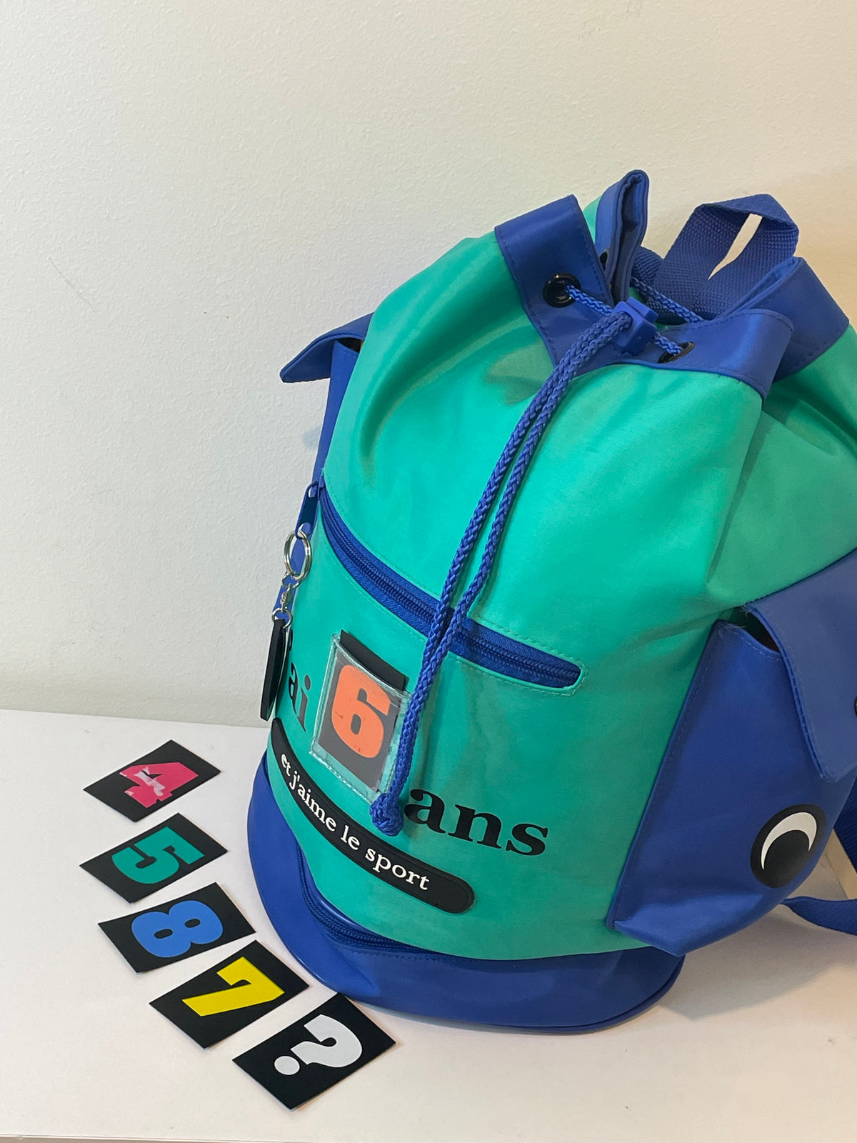 Sac à dos enfant bleu et turquoise avec multiples rangements, poches latérales et compartiment chaussures séparé. Pratique pour école, sport et sorties.