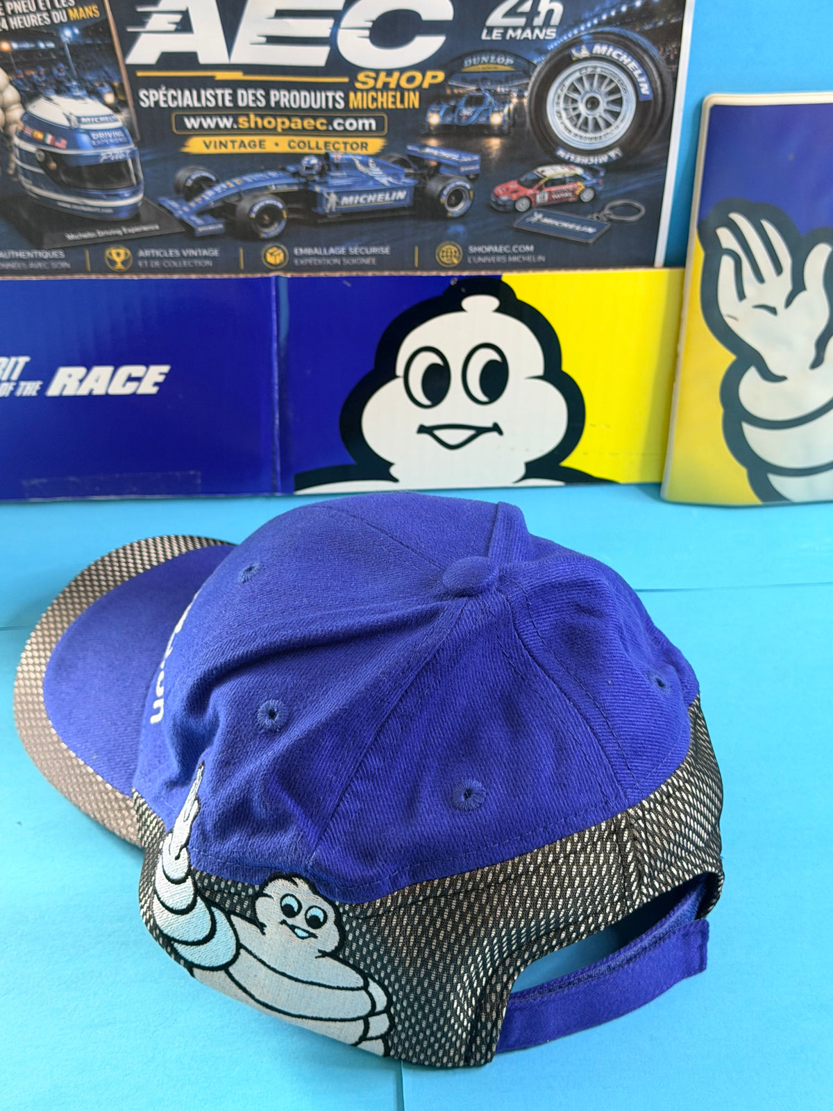 Vue arrière de la casquette Michelin Competition avec Bibendum brodé et bande décorative noire et grise.