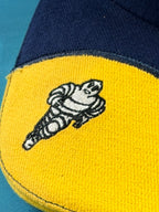 Détail du Bibendum Michelin brodé sur la visière jaune de la casquette Formula 1.