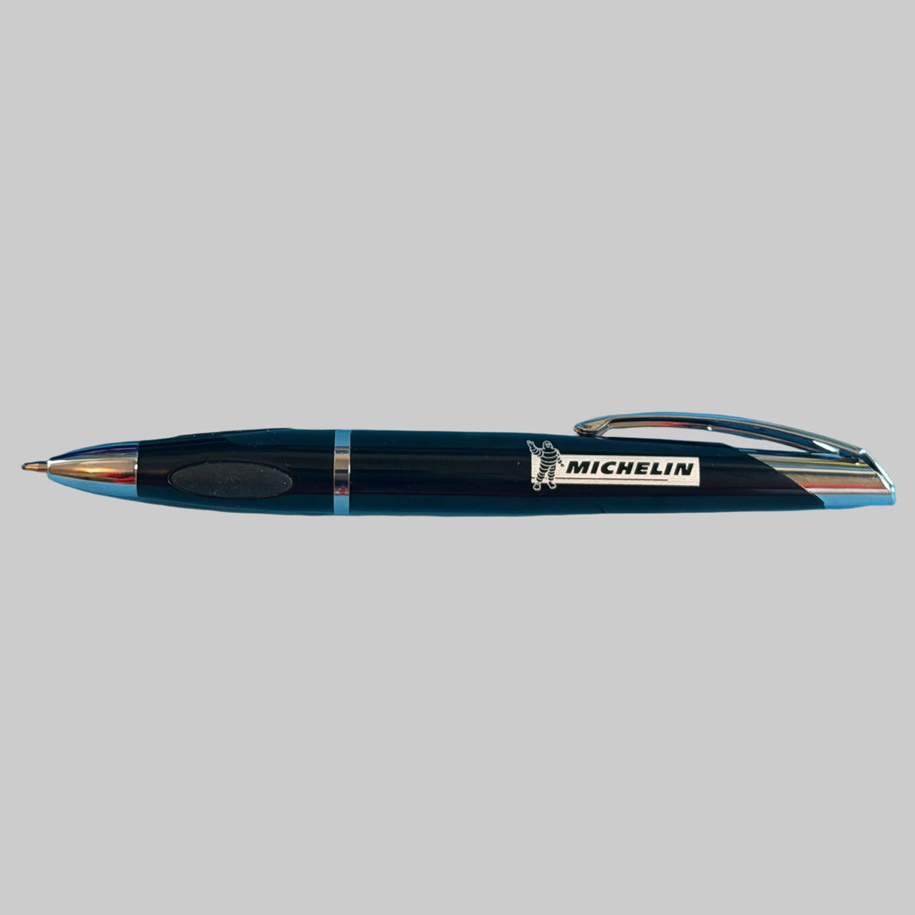 Stylo Michelin Bibendum noir et chrome présenté en entier avec logo Michelin, objet de collection avec mine neuve.