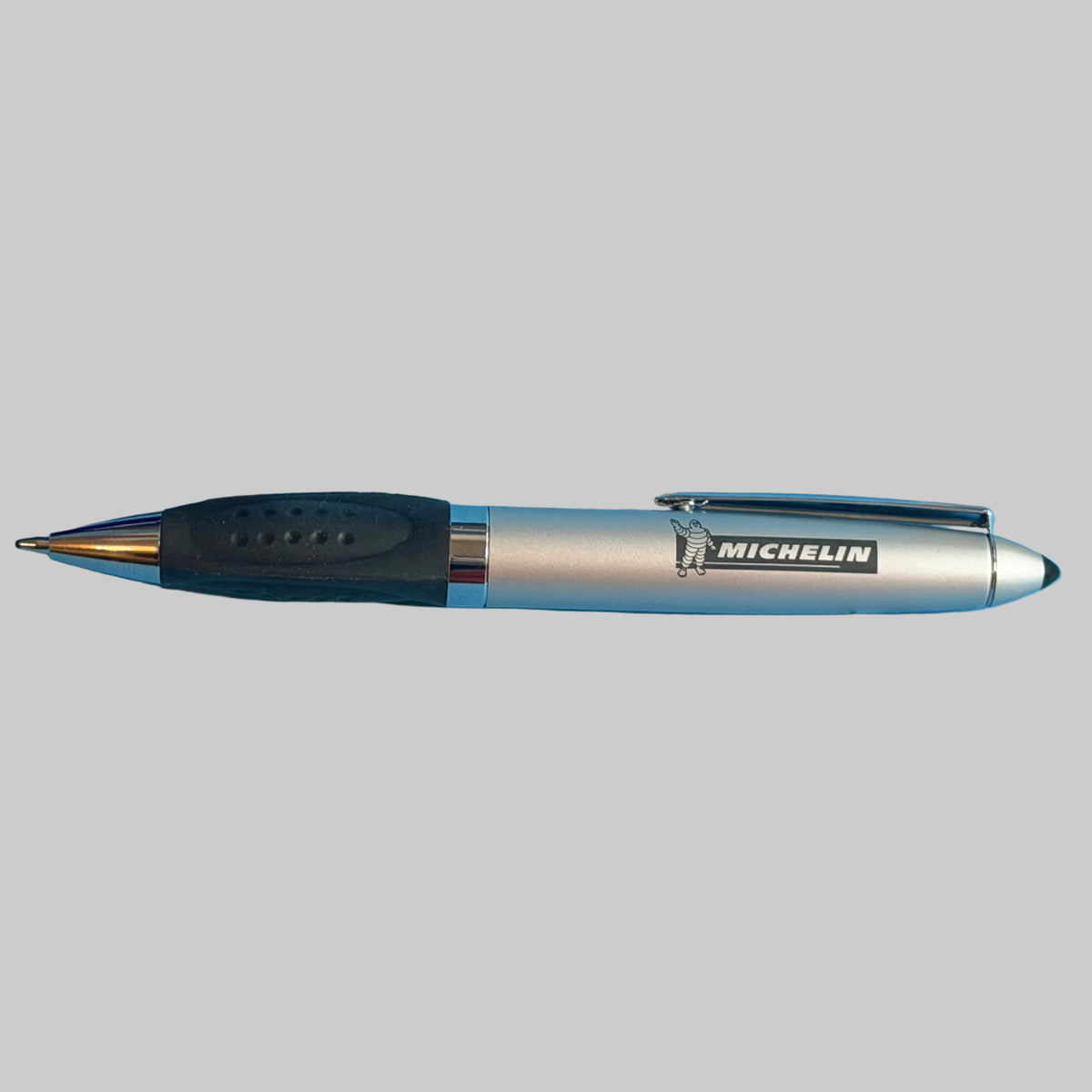 Vue complète du stylo Michelin argenté avec grip noir, finitions chromées et logo Bibendum.