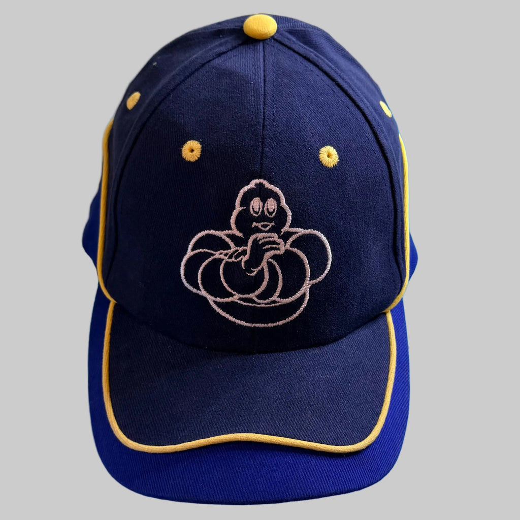Superbe broderie du Bibendum Michelin sur fond bleu marine, sublimée par les finitions jaunes.
