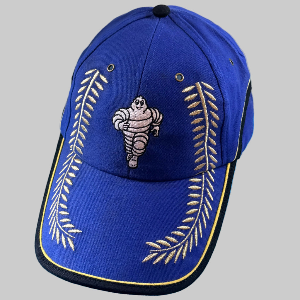 Casquette Michelin Podium bleue neuve avec Bibendum et grands lauriers dorés brodés sur la face avant et la visière.