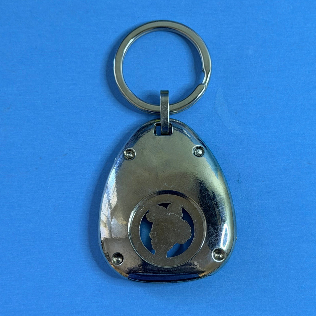 Porte-clés Michelin Bibendum en métal avec médaillon central ajouré et personnage en relief