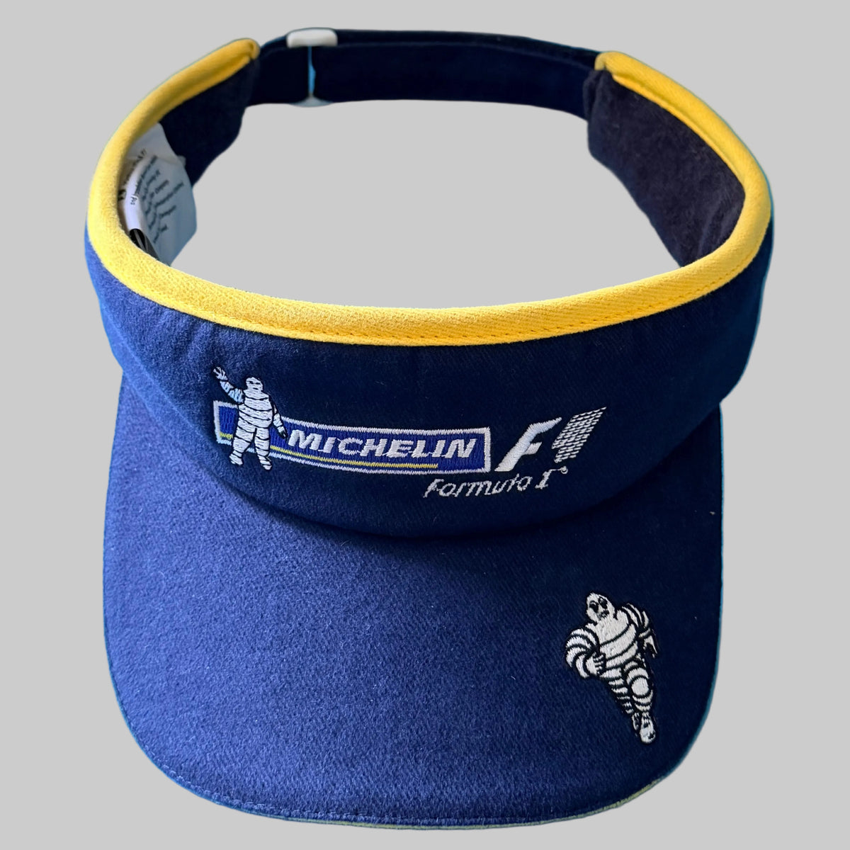 Photo 1 : Visière Michelin Formula 1 Spirit of the Race bleu marine et jaune avec logos F1 et Bibendum brodés.