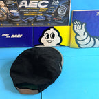 Vue arrière de la casquette Michelin noire montrant les panneaux de tissu, les œillets d'aération et la patte de réglage beige.