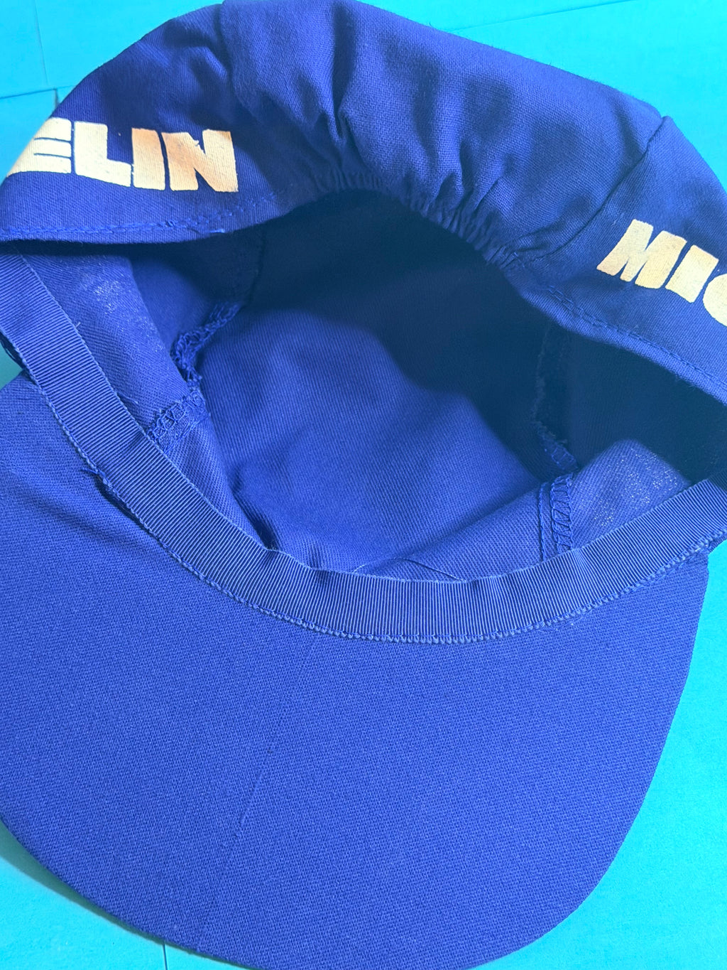 Vue intérieure de la casquette Michelin vintage bleue montrant la visière, les coutures et l’état de conservation.