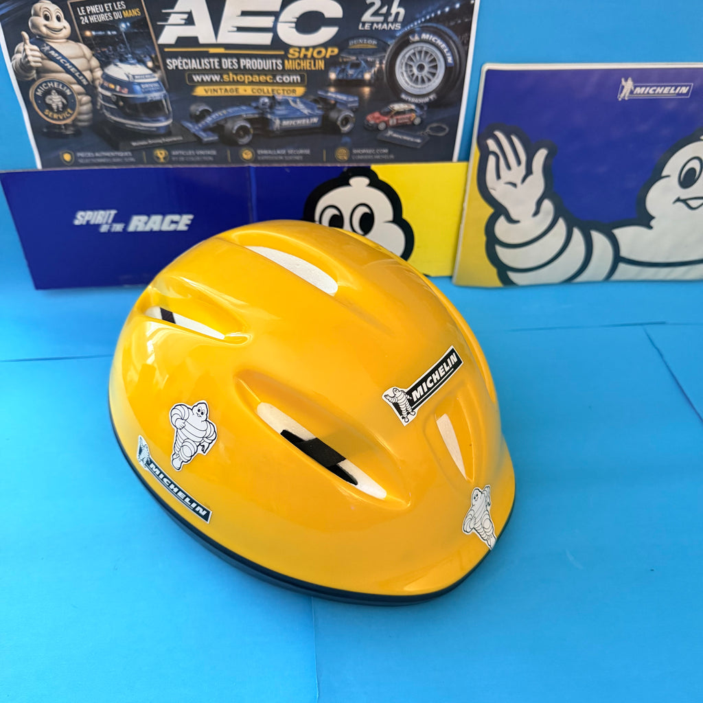 Casque enfant Michelin jaune brillant avec autocollants Bibendum et ouvertures d'aération latérales.
