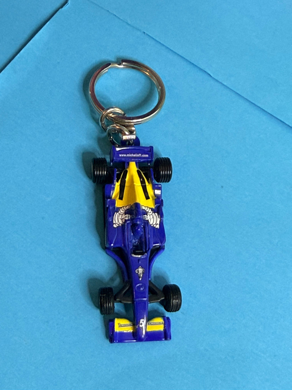 Porte-clé MICHELIN F1 monoplace bleu et jaune – vue de dessus avec Bibendum